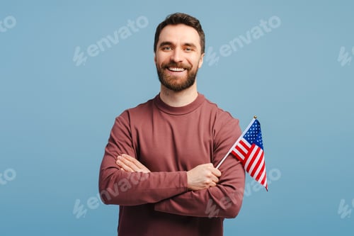Preview: Portrait of handsome, attractive man wearing stylish casual clothes holding American flag