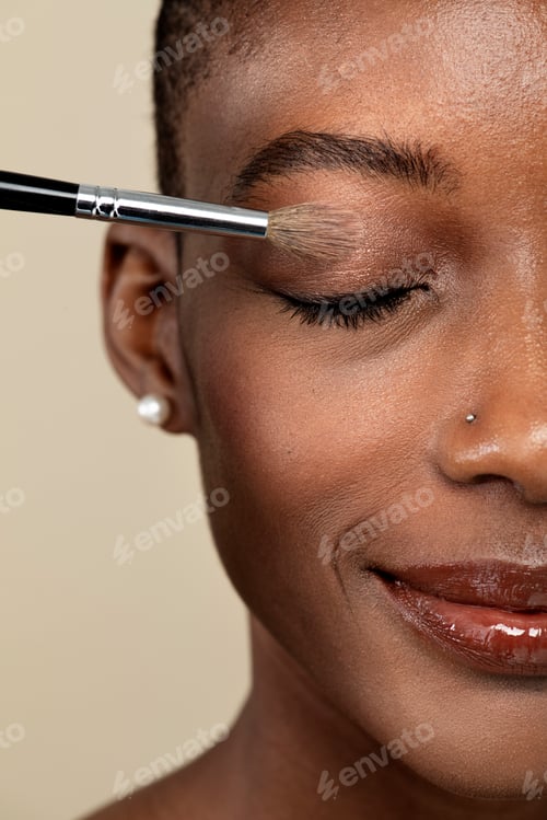 Preview: Makeup artist applying eye shadow on a black woman