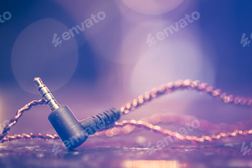 Preview: Headphone jack on blurred background with stage lighting.
