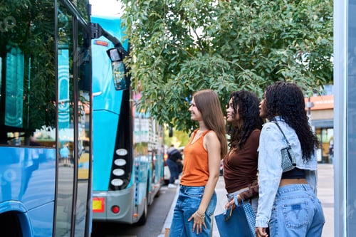 Preview: Young women waiting for bus at bus stop in city center