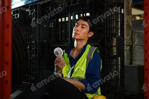 Preview: Exhausted man warehouse worker sitting in on floor feeling tired from hard work and hot temperature