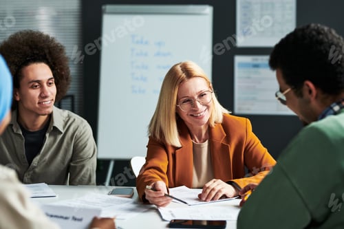 Preview: Happy mature teacher of linguistics explaining something to one of students