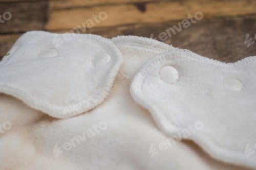 Preview: Closeup shot of organic white baby diapers on a wooden surface
