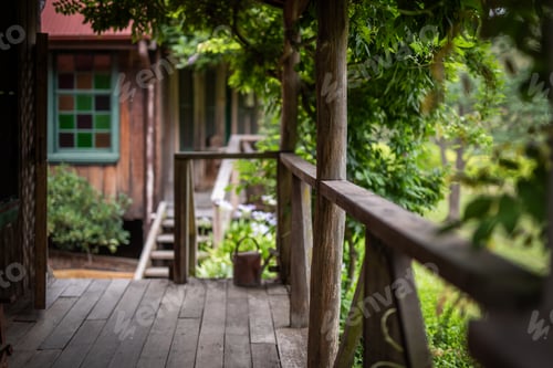 Preview: Rustic wooden porch, green foliage, cozy cabin retreat