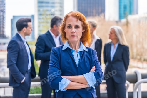 Preview: Redheaded Executive Portrait with Business Team in Urban Commercial District