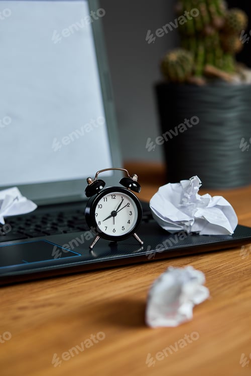 Preview: Workplace, wooden office desk with clock, sheet of paper, laptop, notebook, crumpled paper