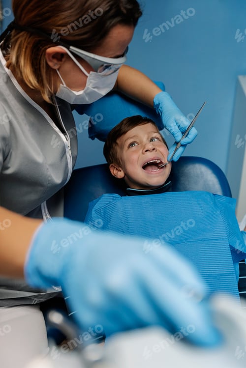 Preview: Dentists with a patient during a dental intervention to boy