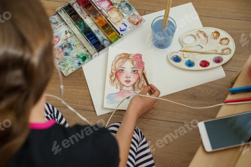 Preview: Teenager girl draws with watercolors, pencils, listening to music on headphones.