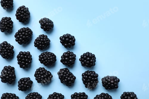 Preview: Tasty ripe blackberries on light blue background, flat lay. Space for text
