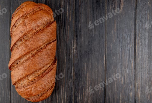 Preview: top view of black bread on wooden background with copy space