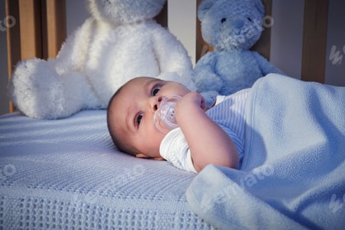 Preview: Baby boy and teddy bears in crib at night