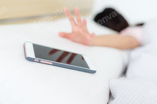 Preview: Young woman sleeping in bed with phone