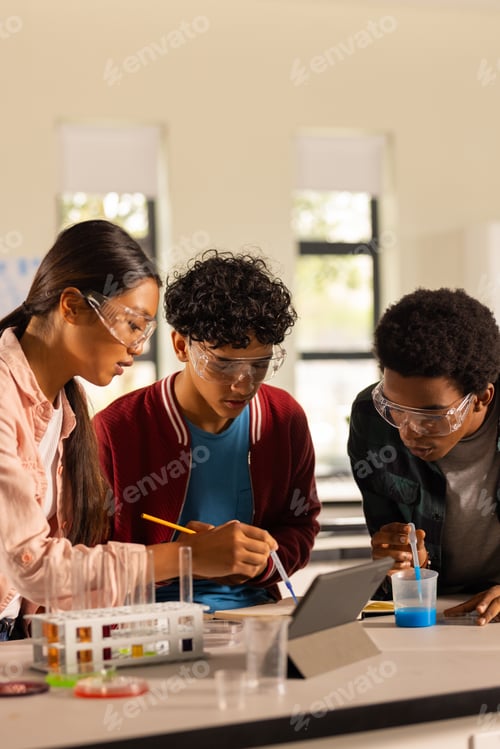 Preview: Conducting science experiment, teenagers using tablet and lab equipment in high school