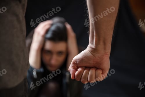 Preview: Woman abuse, Young woman scared, male clenched fist close up. Domestic violence