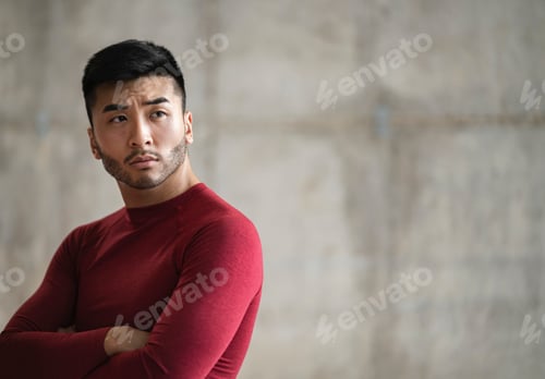 Preview: Contemplative Man with Arms Crossed Wearing a Red Shirt