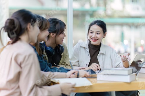 Preview: Group of young Asian college students sitting on a bench in a campus relaxation area, talking