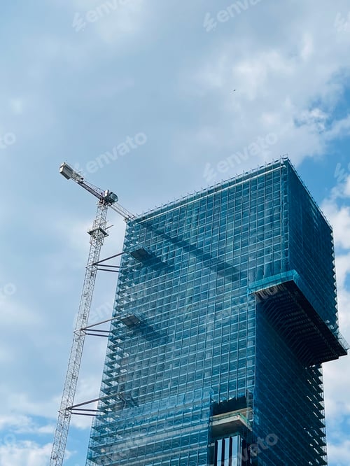 Preview: Photo of a building under construction with cloudy sky as background.