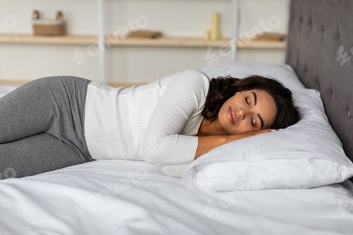 Preview: Young African American female sleeping in bed