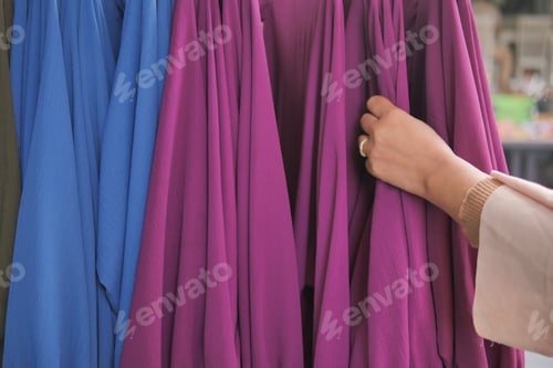 Preview: woman choosing clothes in shop.