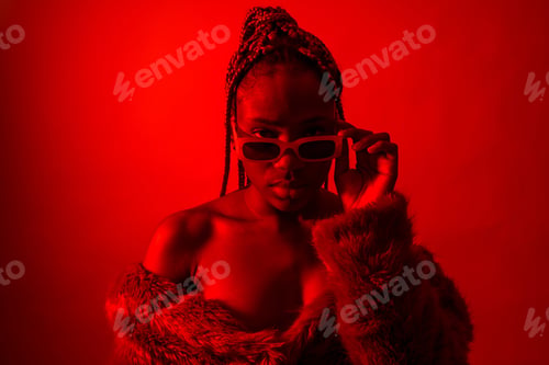 Preview: Attractive black ethnic woman with braids with red led lights, trap dancer with seductive look