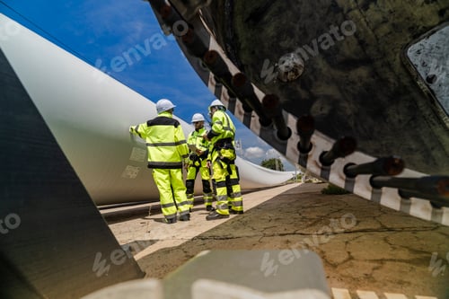 Vista previa: los ingenieros con equipos de seguridad de alta visibilidad realizan una inspección detallada de la pala de una turbina eólica
