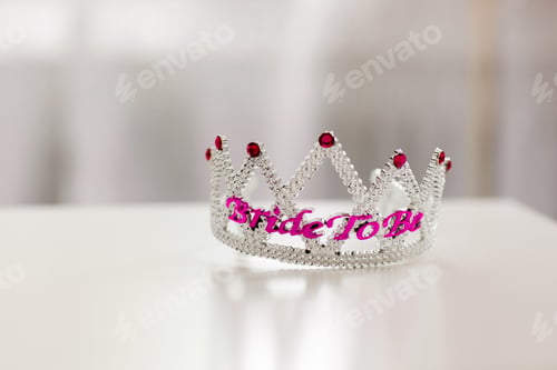 Preview: Plastic crowned jewel crown or tiara with purple beads on a white background with the word bride