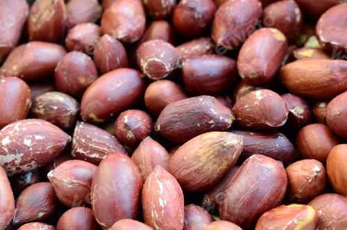 Preview: Peanut. A lot of small yellow nuts with brown peel. Background texture