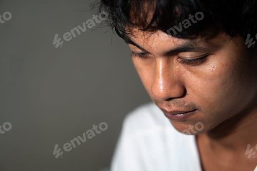 Preview: Pensive young man looking down