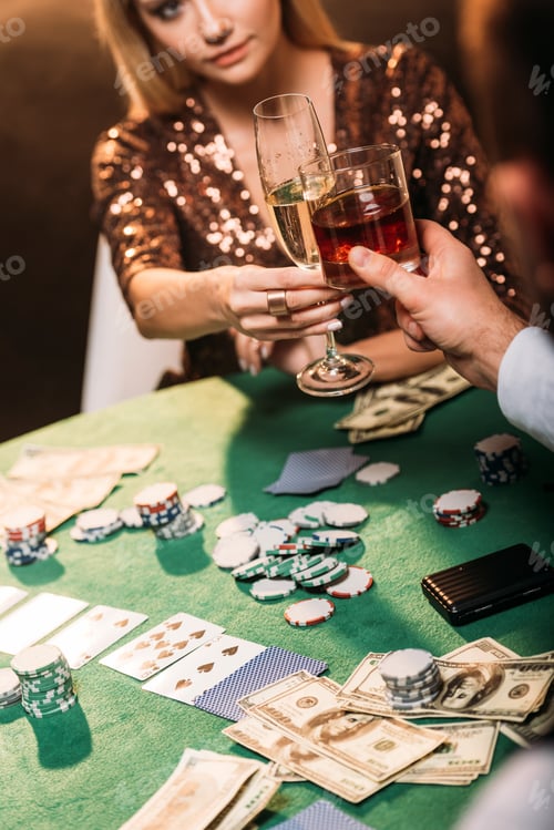 Preview: cropped image of girl and croupier clinking with glasses of alcohol drinks while playing poker at
