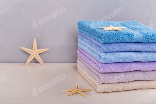 Preview: Stack of colorful bath towels on light background.