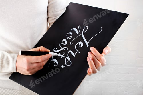 Preview: Woman writing on a small chalkboard zero waste lettering