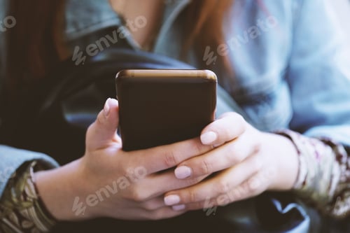 Preview: hands of unrecognizable young woman using her smartphone or mobile phone