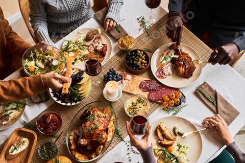 Preview: Diverse group of friends enjoying homemade food at festive dinner table