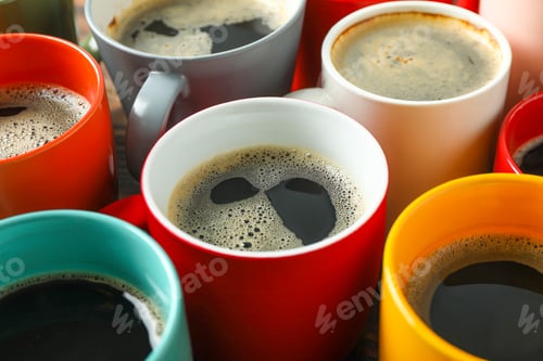 Preview: Multicolored cups of coffee on wooden table as background, closeup