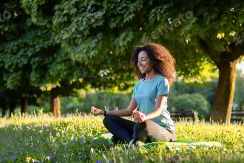 Preview: Woman meditating in a serene park setting with sunlight filtering through the trees, embodying