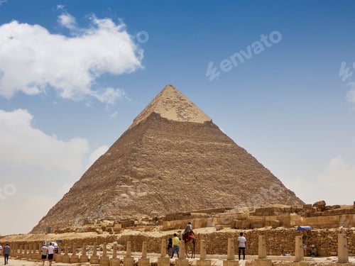 Preview: Group of people stand in awe at the base of the pyramid of Giza
