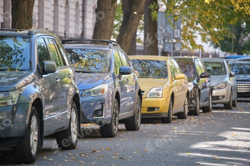 Preview: City traffic with many cars parked in line on street side