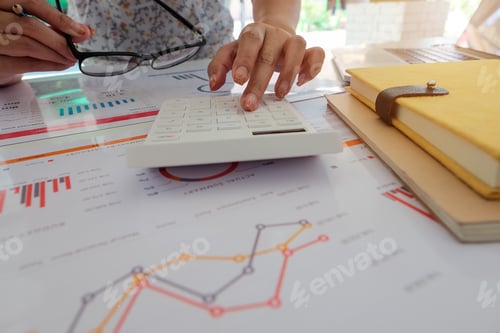 Preview: Close up of businessman or accountant hand holding pencil working on calculator to calculate