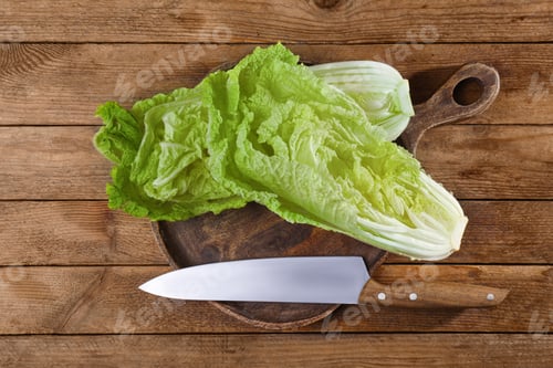 Preview: Halves of fresh ripe Chinese cabbage and knife on wooden table, flat lay