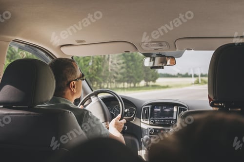 Preview: Young man holding steering wheel while driving car. Road trip adventure