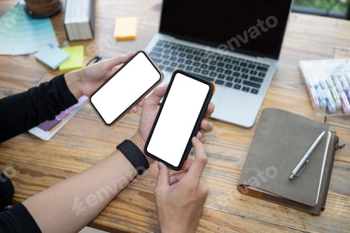 Preview: Cropped image of young couple using smart phones at home.