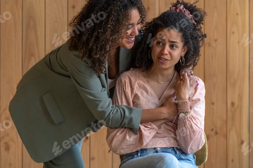 Preview: Two women share a comforting embrace, one offering support to the other who appears distressed.