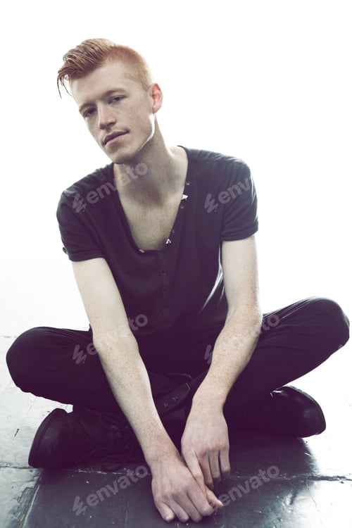 Preview: Dark style. A young man with a red mohawk posing in a black t-shirt and skinny jeans.
