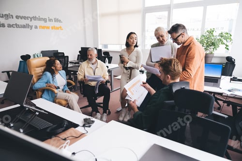 Preview: Coworkers analyzing documents in office
