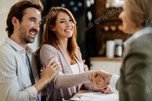 Preview: Young happy couple greeting with real estate agent at their home.
