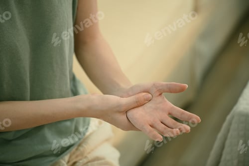 Preview: Closeup young woman hand pain her injury pain from cramp, trigger finger