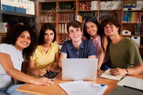 Preview: Portrait of a group of multiracial high school students at library studying, looking camera smiling.