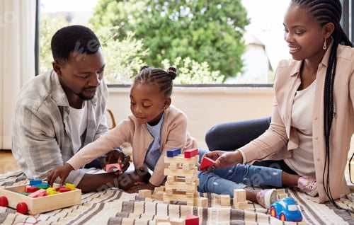 Preview: An architect in the making. Shot of a little girl playing with blocks with her parents at home.