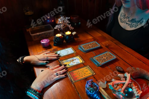 Preview: Fortune teller reading tarot cards on wooden table with candles