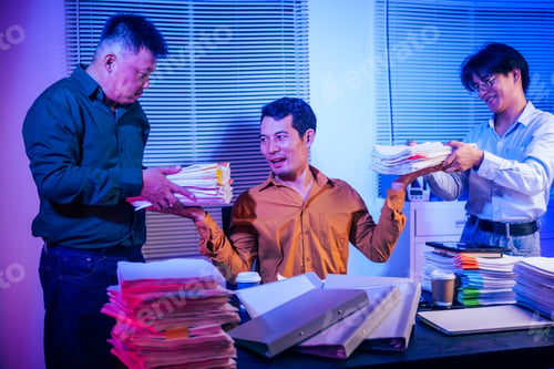 Preview: Three young businessmen work together on laptops in the office at night. They are stressed tired